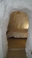 a bed in a cave with a stone wall at Casa Cueva “La Estrella” in Granada