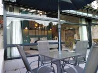 マゴバスクルーフにあるBramasole Boutique Hotelのパティオに置かれたテーブルと椅子、そして傘