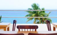 コスメルにあるAlbatros by Bedsfriendsのテーブルと椅子付きのレストランから海の景色を望めます。