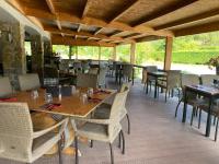 a restaurant with tables and chairs on a patio at Le Plan B - Hôtel 3 étoiles - Restaurant in Ruoms