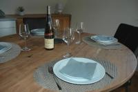 a table with a bottle of wine and plates and glasses at appartement à Colmar in Colmar