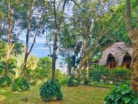 a bunch of bananas hanging from trees in front of a house at Banyan Bay Villas in Ko Jum
