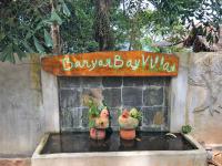 a sign on a wall with two chickens on a fountain at Banyan Bay Villas in Ko Jum