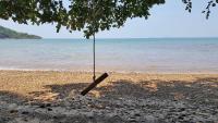a swing hanging from a tree on the beach at Banyan Bay Villas in Ko Jum