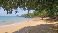a beach with a boat on the water at Banyan Bay Villas in Ko Jum