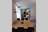 Habitación con mesa, sillas y cocina. en Joli appartement maison, Dol de Bretagne, calme et lumineux, proche Mont-Saint-Michel et Saint-Malo, en Dol-de-Bretagne