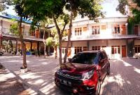 una camioneta roja estacionada frente a un edificio en Pondok Wisata dan Restoran Elim, en Waingapu