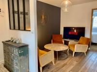 a living room with a table and chairs and a television at LE TROIS B in Beaune