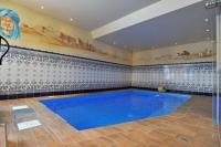 a large blue swimming pool in a room at Hôtel Alpina &amp; SPA in Les Gets