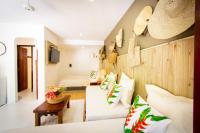 a living room with two beds and a couch at Pousada Por do Sol in Trancoso
