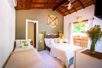 a bedroom with two beds and a window at Pousada Por do Sol in Trancoso
