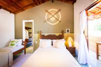 a bedroom with two beds and a large window at Pousada Por do Sol in Trancoso