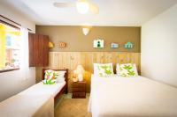 a bedroom with two beds and a window at Pousada Por do Sol in Trancoso