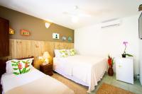 a bedroom with two beds with white sheets at Pousada Por do Sol in Trancoso