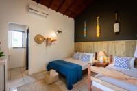 a bedroom with a bed and a couch and a window at Pousada Por do Sol in Trancoso