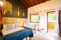 a bedroom with a bed and a chair at Pousada Por do Sol in Trancoso