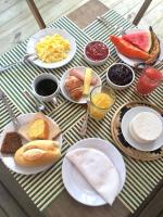 a table with plates of breakfast foods on it at Pousada Por do Sol in Trancoso