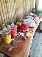 a long wooden table with food and fruit on it at Pousada Por do Sol in Trancoso