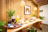 a breakfast table in a wooden room with food on it at Pousada Por do Sol in Trancoso