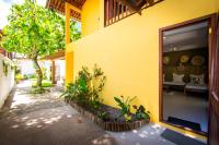 a yellow house with a large glass door with a bedroom at Pousada Por do Sol in Trancoso