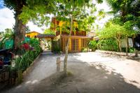 a tree in the middle of a street with a building at Pousada Por do Sol in Trancoso