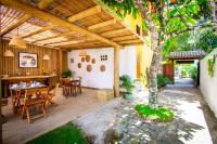 a patio with a table and chairs and a tree at Pousada Por do Sol in Trancoso
