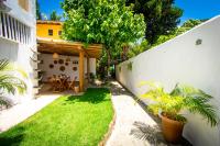 a garden with a table and a white wall at Pousada Por do Sol in Trancoso