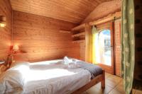 a bed in a wooden room with a window at Chalet-Hôtel de l&#39;Etape in Les Contamines-Montjoie