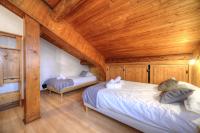two beds in a room with a wooden ceiling at Chalet-Hôtel de l&#39;Etape in Les Contamines-Montjoie
