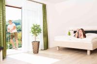 A bed or beds in a room at Weingut-Gästezimmer UHL