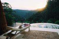 a bench sitting on a balcony with a view of a mountain at Timamoon Lodge in Hazyview