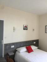 a bedroom with a white bed with a red pillow at Hotel TGV in Quimper