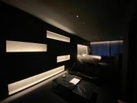 Habitación oscura con cama y mesa. en Randor Residence Hiroshima Suites, en Hiroshima