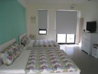 a bedroom with two beds and a flat screen tv at Penghu 123 V-Stone in Magong