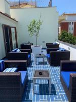a patio with wicker chairs and a potted tree at Hotel Nice in Sorrento