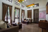 Una sala de estar con sofás, mesas y ventanas. en Jambuluwuk Residence Menteng, en Yakarta
