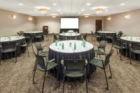 a conference room with tables and chairs and a screen at Crowne Plaza Chicago O'Hare Hotel & Conference Center by IHG in Rosemont