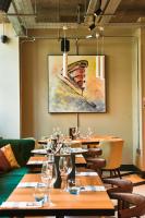 a row of tables in a restaurant with a painting on the wall at The Chamberlain in London