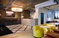 a bar with yellow chairs and tables in a room at The Chamberlain in London