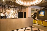 a lobby with a reception desk and yellow chairs at The Chamberlain in London