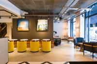 a waiting room with yellow chairs and tables at The Chamberlain in London