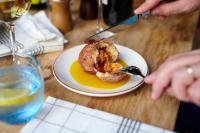 a person eating a plate of food on a table at The Chamberlain in London