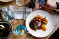 a table with a plate of food and a glass of wine at The Chamberlain in London