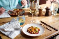 a table with a plate of food and a glass of wine at The Chamberlain in London