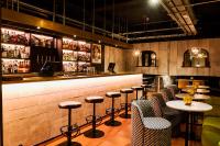 a bar with tables and stools in a restaurant at The Chamberlain in London
