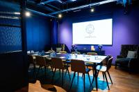 a meeting room with a table and chairs and a screen at The Chamberlain in London