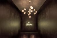 a chandelier in a dark room with a sign at The Chamberlain in London