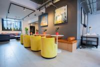 a lobby with yellow chairs and a table at The Chamberlain in London