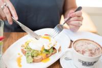 a person eating a plate of food with eggs and a cup of coffee at The Chamberlain in London