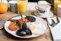 a plate of breakfast food on a wooden table at The Chamberlain in London